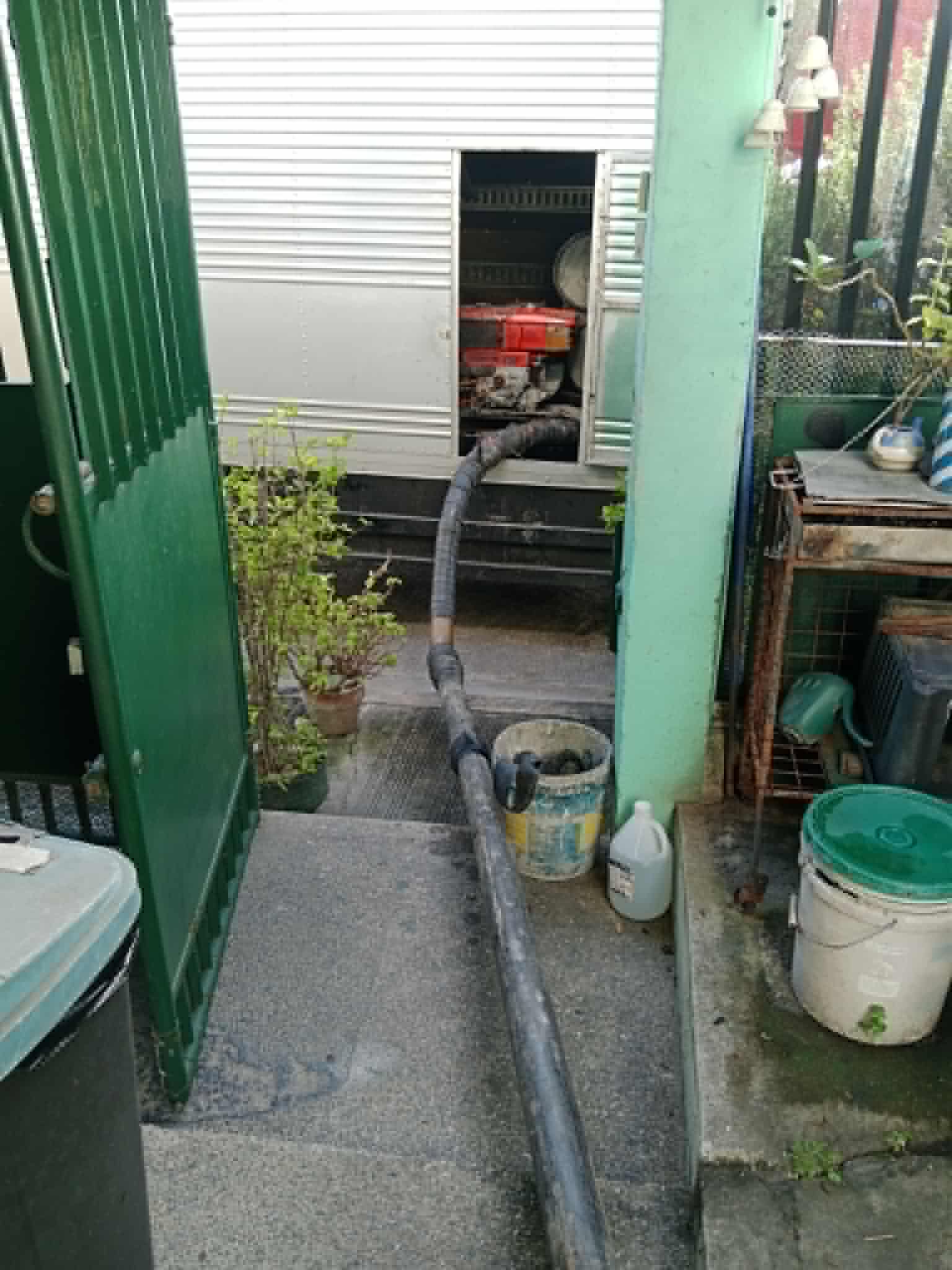 Septic pump-out hose routed from a generator unit through a residential passageway