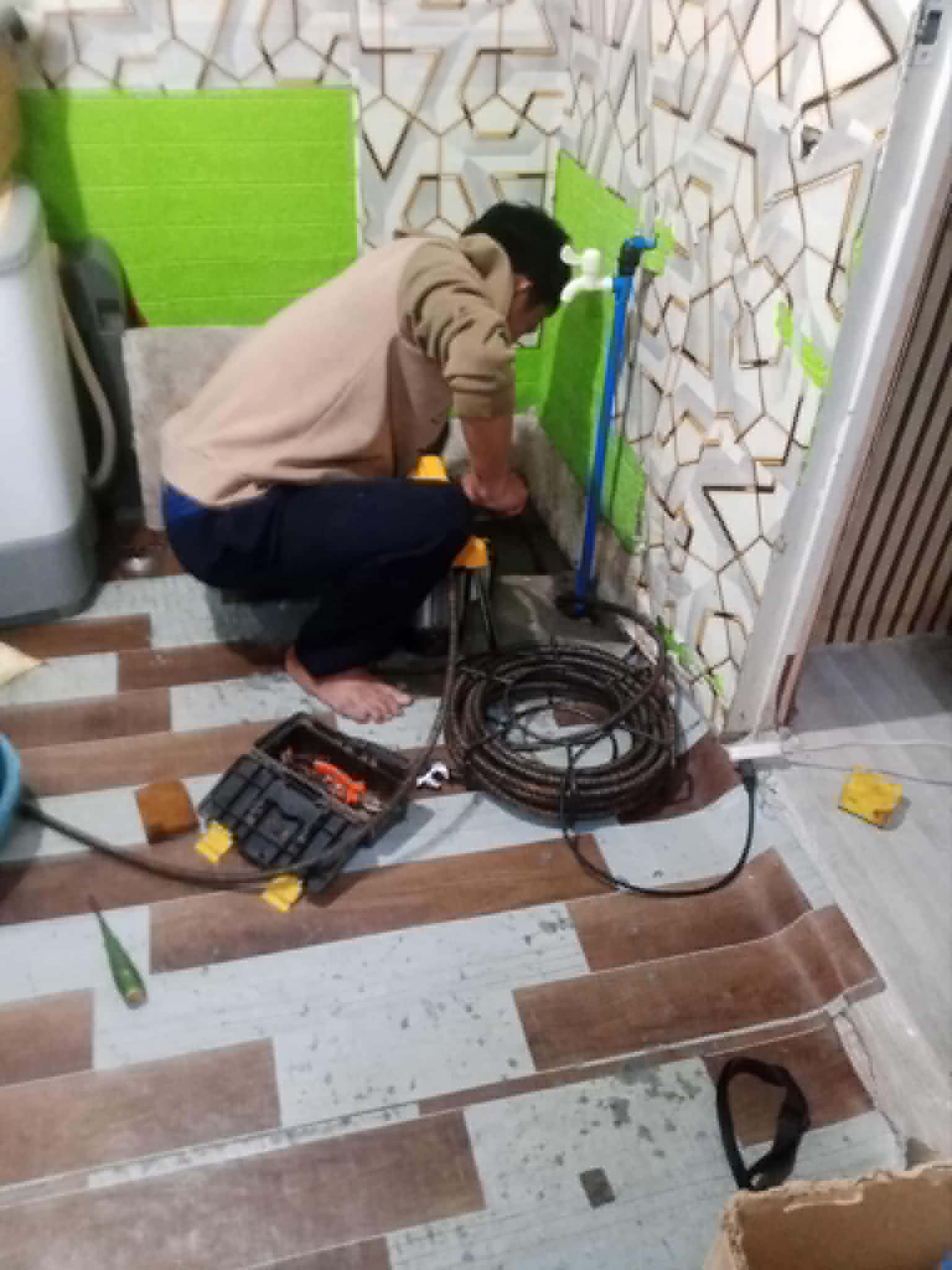 Technician working on a floor drain with snake machine